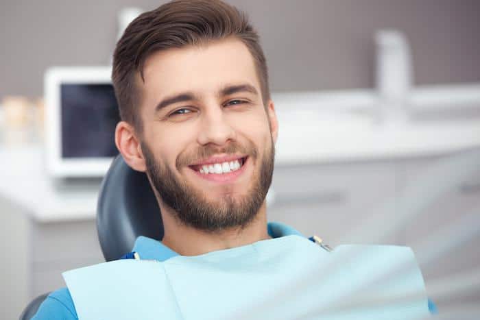 young man smiling after getting his teeth cleaned